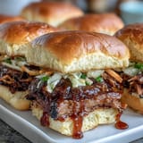 Smoky, tender BBQ brisket sliders with tangy sauce and crunchy slaw, served on soft toasted buns for a flavorful bite.