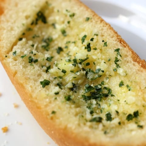 Freshly baked Garlic Bread with melted butter and minced garlic, paired next to a creamy tomato soup for dipping.