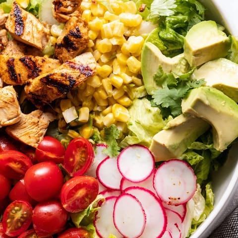 Fresh lime dressing coats this hearty salad, served in a rustic bowl with bright cherry tomatoes and red onions for a refreshing lunch.  