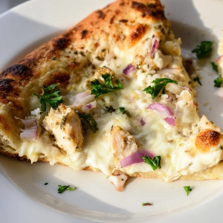 Sliced Chicken Alfredo Pizza shows bubbling mozzarella and Parmesan, with a side salad for a fresh dinner idea.  