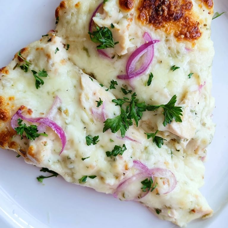 Close-up of Chicken Alfredo Pizza with garlic-herb chicken and golden crust, perfect for family-style Italian-American meals.