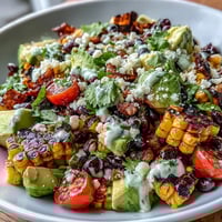 Vibrant grilled corn and black bean taco salad drizzled with zesty lime dressing.